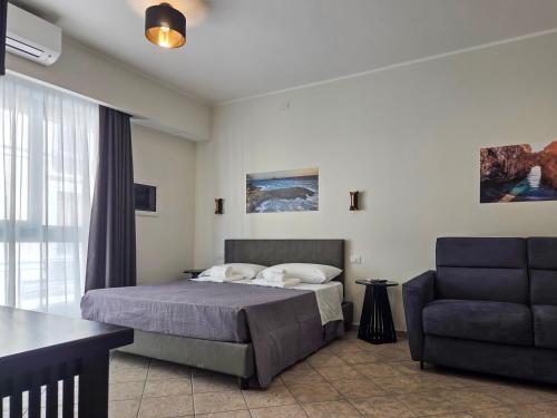 a bedroom with a bed and a blue chair at The Gallery Rooms in Belvedere Marittimo