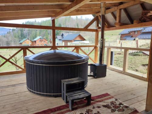 a large barrel sitting on a deck with a stove at Manor "U Bervinovy" in Yaremche