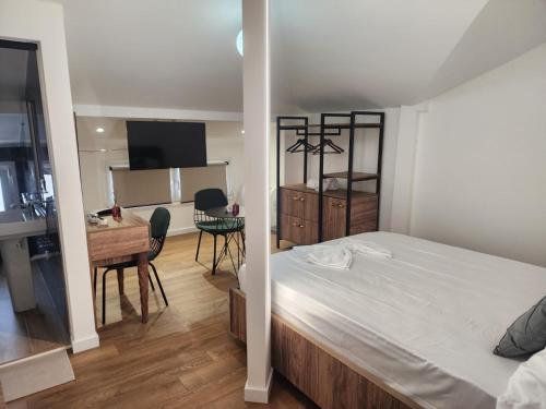 a bedroom with a bed and a desk and a kitchen at Vila Astrit in Fier
