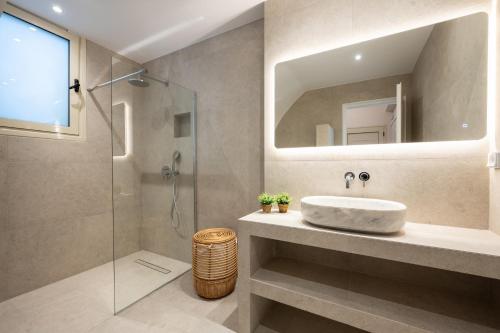 a bathroom with a sink and a glass shower at Sandy Pines Villas in Alykes