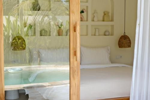 a room with a bed and a glass window at Promo - Private 1BR villa for couples in Kuta Lombok