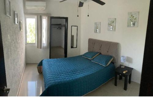 a bedroom with a blue bed and a window at Casa Flamingo in Bucerías