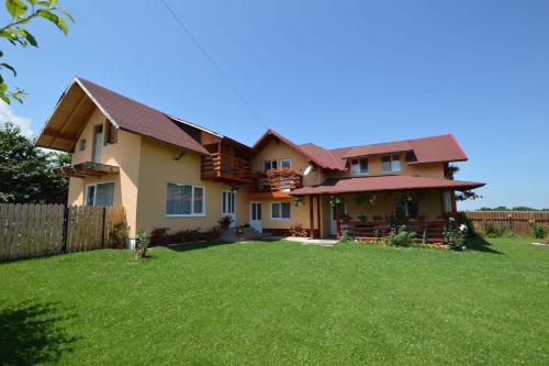 a house with a fence and a yard at Pensiunea Gratiela in Stațiunea Climaterică Sâmbăta