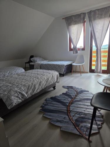 a bedroom with two beds and a rug on the floor at Konoba Taline Sokolac in Rešetnica