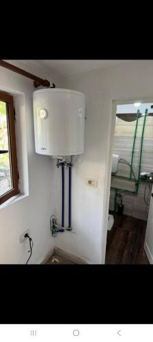 a bathroom with a sink and a light on the wall at Hostel Sherifaj in Valbonë