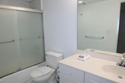 a bathroom with a toilet and a sink and a mirror at Ocean Reserve STR-01045 in Sunny Isles Beach