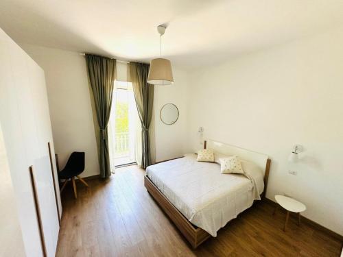a white bedroom with a bed and a window at Casa Lucia in Marta