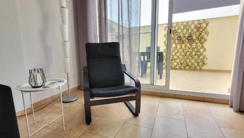 a black chair and a table in a room at Somnis del Delta, Apartamento Deltebre, Delta Ebro in Deltebre