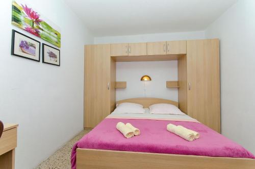a bedroom with a large bed with a pink blanket at Apartment Seaside Peace in Vela Luka