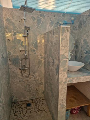 a bathroom with a shower and a sink at Beach House in Saly Portudal