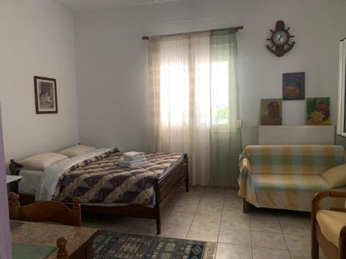 a bedroom with a bed and a window and a couch at Το σπίτι της Ελένης in Vlakhiá