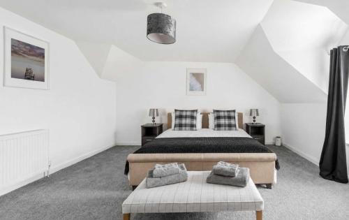 a bedroom with two beds and two chairs in it at Dunallan Farm Cottage with Optional Hot Tub & Stunning Views in Island of Bute