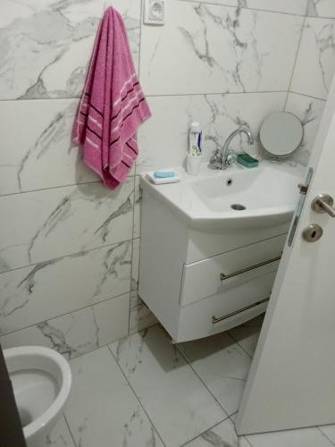 a white bathroom with a sink and a pink towel at Ranč Pavić in Banja Luka