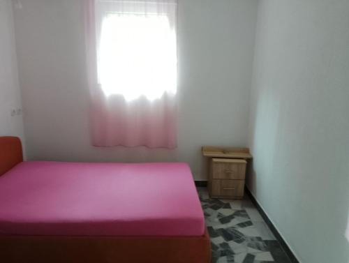 a pink bed in a room with a window at Ranč Pavić in Banja Luka