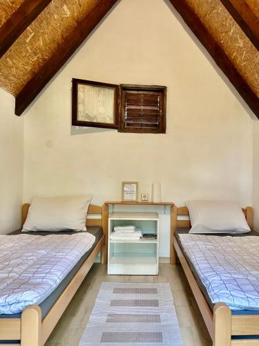 two beds in a room with a nightstand between them at Camping Lukač in Kutina