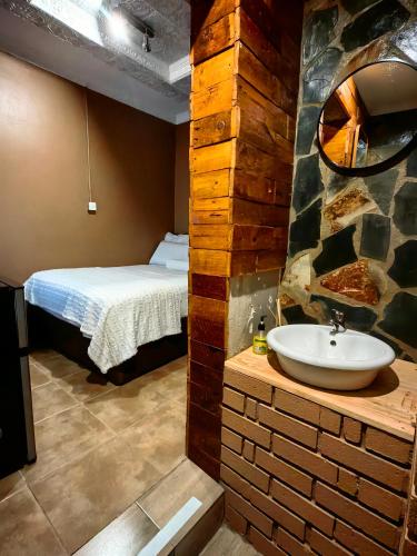 a bathroom with a bed and a sink in a room at Mukani B&B in Lobatse