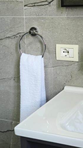 a white towel hanging on a towel rack next to a sink at Selimi House in Shirokë