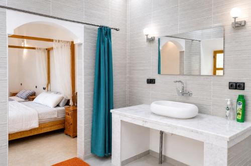 a bathroom with a sink and a bedroom with a bed at Kasbah ben hamou in Nkob