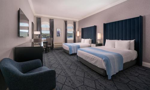 a hotel room with two beds and a chair at Prestige Oceanfront Resort, WorldHotels Luxury in Sooke