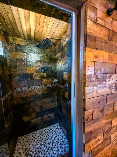 a shower in a room with a brick wall at Mukani B&B in Lobatse