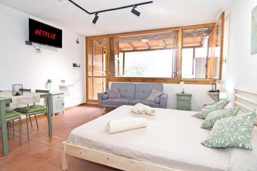 a bedroom with a bed and a couch and a table at Charming Open Space in Costa Smeralda in Olbia