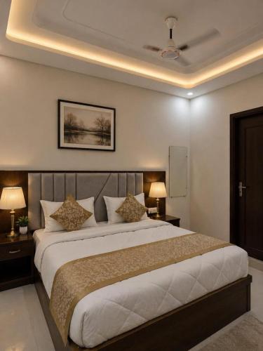 a bedroom with a large bed with two tables and two lamps at Hotel Urban Inn - The RK Hospitality Group #Prem Mandir #Chaar Dham Fully AC in Vrindāvan