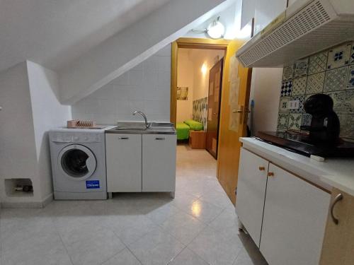 a kitchen with a washing machine and a sink at Confort home L da Vinci in Quattromiglio
