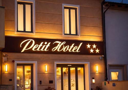 ein Schild für ein kleines Hotel an der Seite eines Gebäudes in der Unterkunft Petit Hotel in Prato