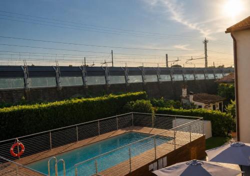 Ein Swimmingpool auf einem Balkon mit einem Zug im Hintergrund in der Unterkunft Petit Hotel in Prato