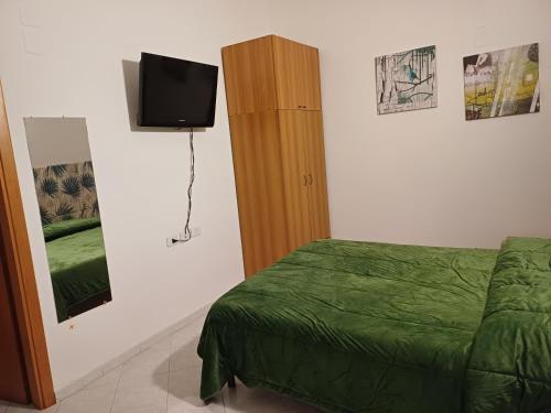 a bedroom with a bed and a tv on a wall at Confort home L da Vinci in Quattromiglio