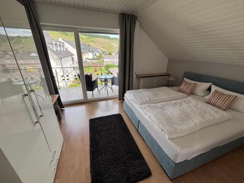 a bedroom with a bed and a large window at Gästehaus Am Rebenhang in Mehring