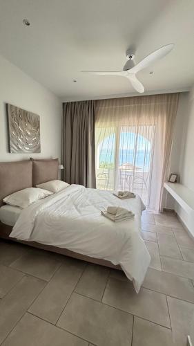 a bedroom with a large bed with a ceiling fan at Villa Panorama Astrakeri Beach in Astrakeri