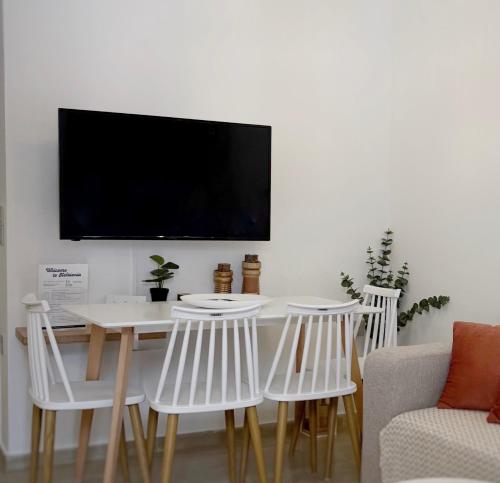 a living room with a table and chairs and a tv at Central in Argostoli