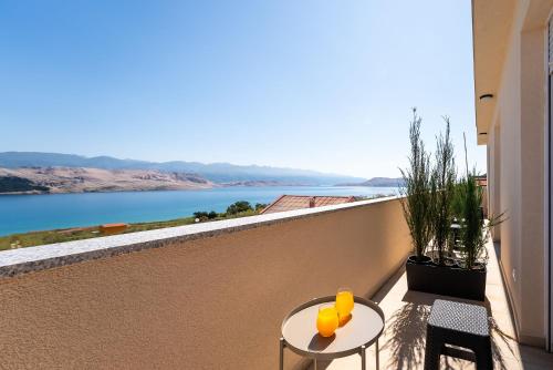 a balcony with a table and a view of the water at Villa Serenity Pag Sv. Marko in Pag