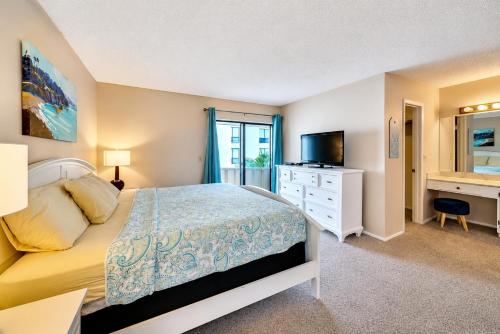 a bedroom with a bed and a desk and a television at Siesta Key Beach - 2 Bedroom - 3 Beds - 3 Bathroom Duplex with Heated Swimming Pool in Siesta Key