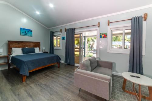 a bedroom with a bed and a couch and a table at Blue Horizon Studios in Roatán
