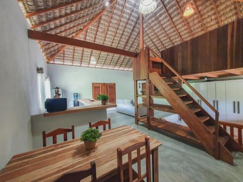 a dining room with a wooden table and a staircase at Kite Mansion Arpoador in Tutóia