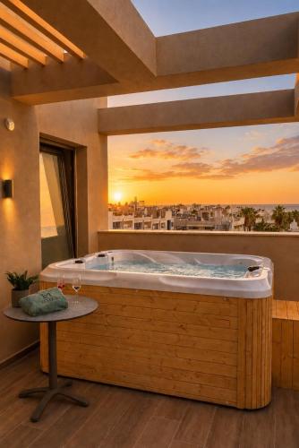 a hot tub in a room with a sunset at Lemar Luxury Apartments in Hersonissos