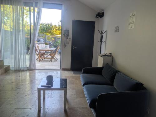 a living room with a couch and a table at Maison moderne et lumineuse in Cavaillon