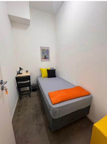 a small bedroom with a bed and a desk at Pinheiros Hostel & Food in São Paulo