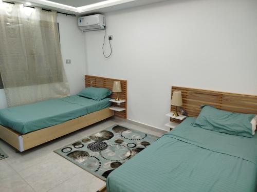 a room with two beds and a rug at Tawfik in Midoun