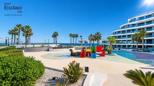 a resort pool with a playground and a building at Infinity View Penthouses by NRAS in Arenales del Sol