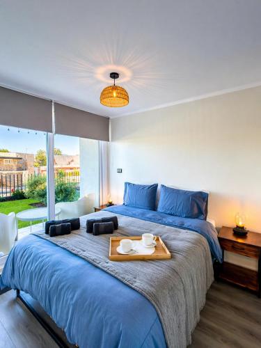 a bedroom with a large bed with a tray on it at Departamento Villarrica Vista al Volcán y Piscina in Villarrica