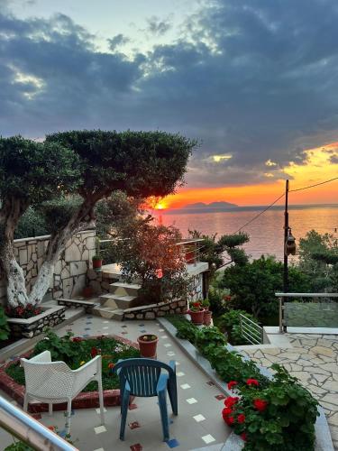 a view of the sunset from a patio with chairs and flowers at Vila Endry in Vlorë