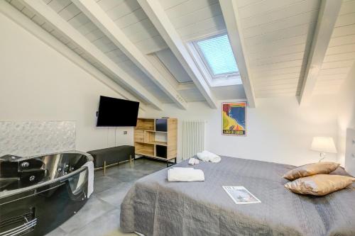 a bathroom with a sink and a bed in a room at Loft & Jacuzzi - Happy Rentals in Riva del Garda