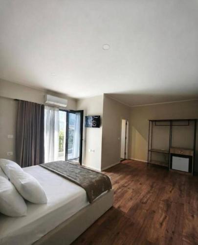 a bedroom with a large bed and a large window at Velia Rooms in Përmet