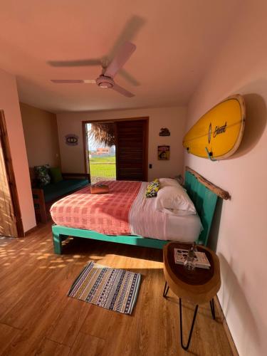 a bedroom with a bed with a surfboard on the wall at Mojarra Beach Casa Privada-Santa Veronica in Salina de Rey