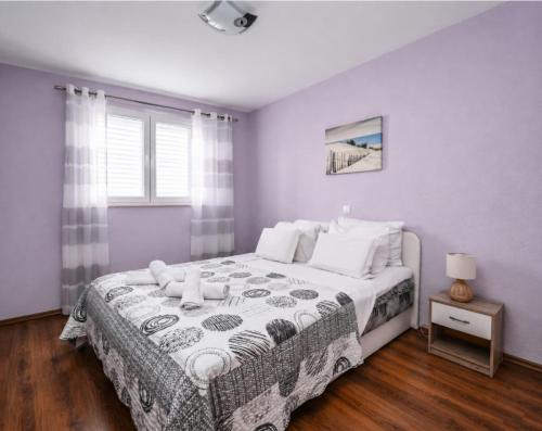 a bedroom with a large bed and a window at Mikuljan Apartments- Free Parking -5 Min by Walk to Beach in Stobreč