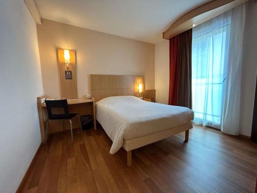 a bedroom with a bed and a desk and a chair at ibis Esch Belval in Esch-sur-Alzette