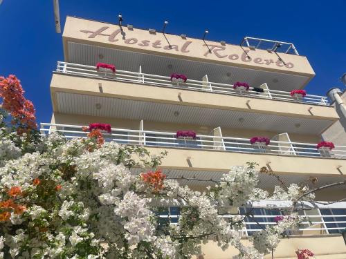 a tall building with flowers in front of it at Hostal Roberto in Palmanova